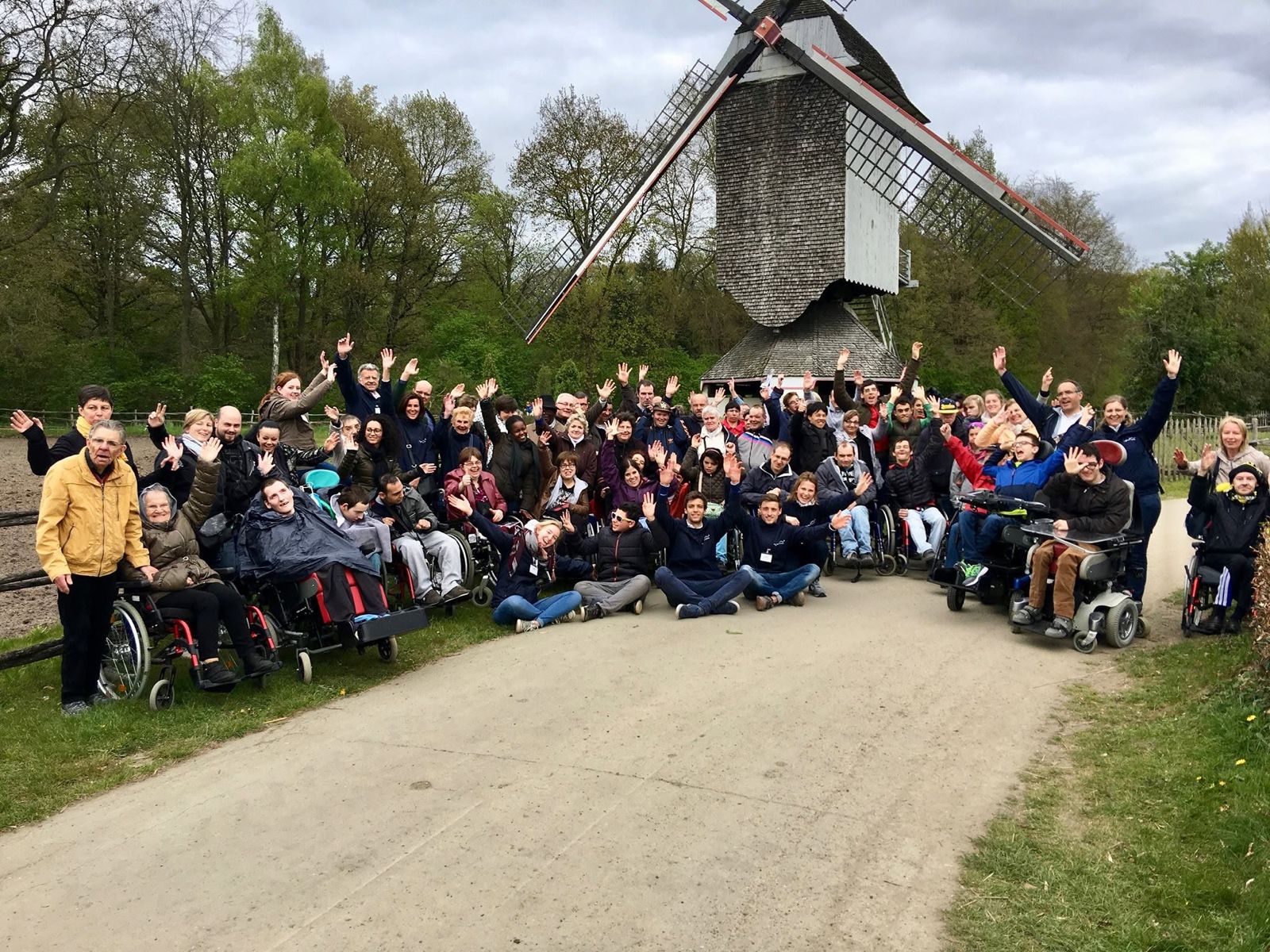 Een grote groep zwaait naar de camera tijdens een daguitstap.
