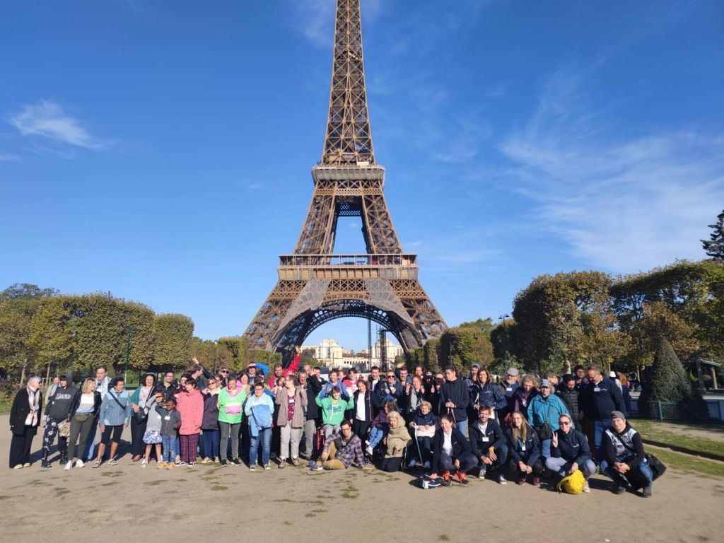 Een grote groep poseert voor de Eiffeltoren.