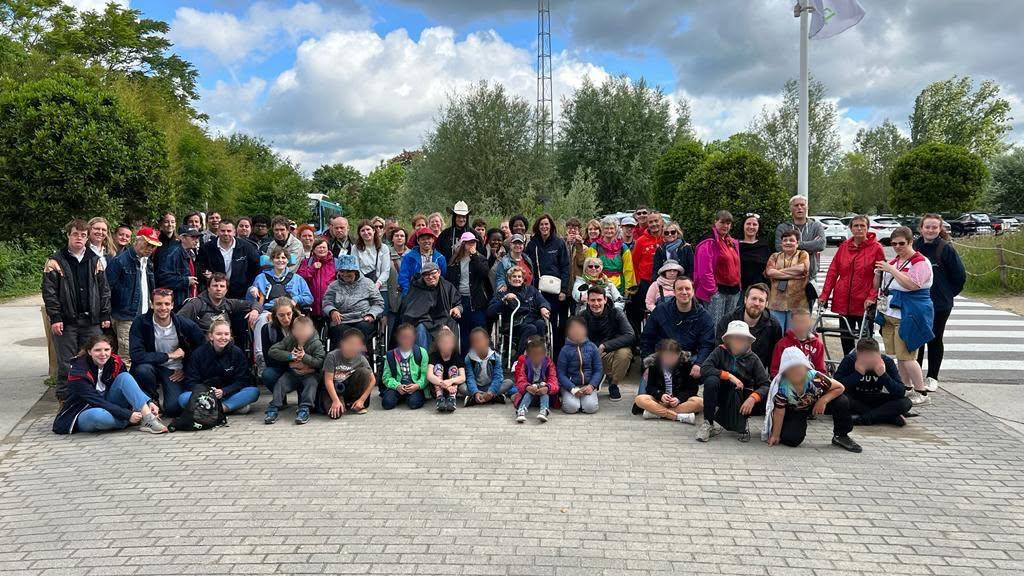 De groep poseert buiten bij een park.