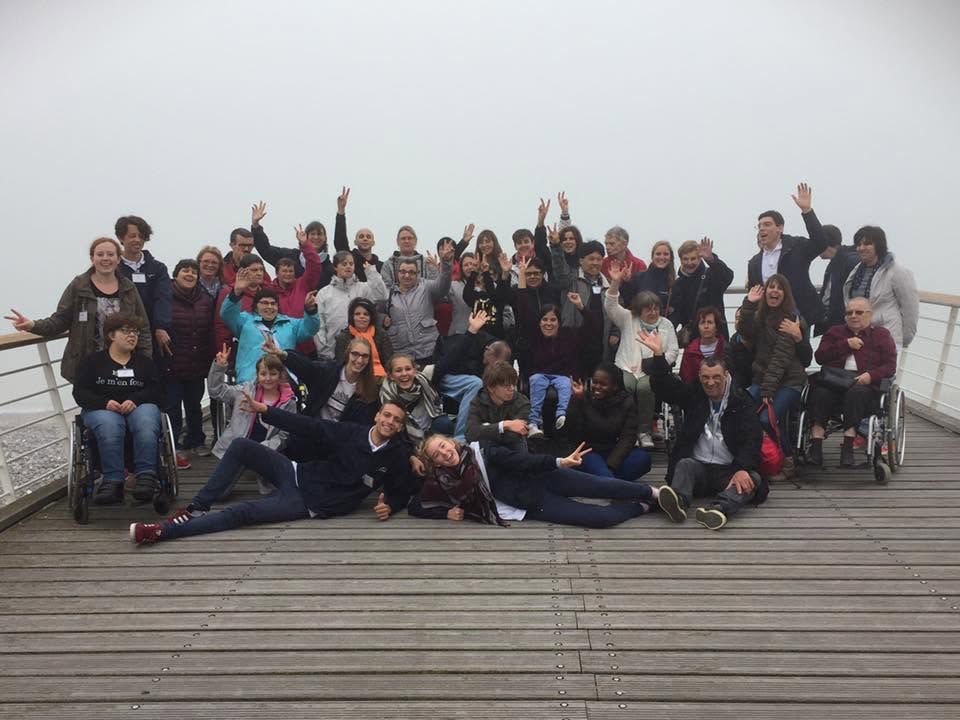 De groep zwaait naar de camera vanaf een ponton in de mist.