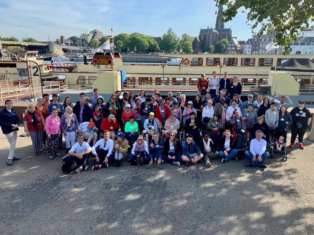 De groep poseert op een kade voor een boot.
