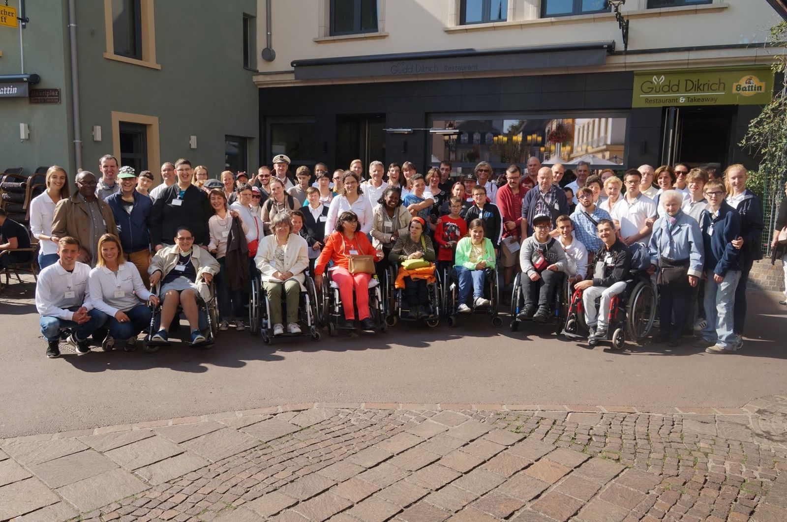 De groep poseert in een straat voor een restaurant.