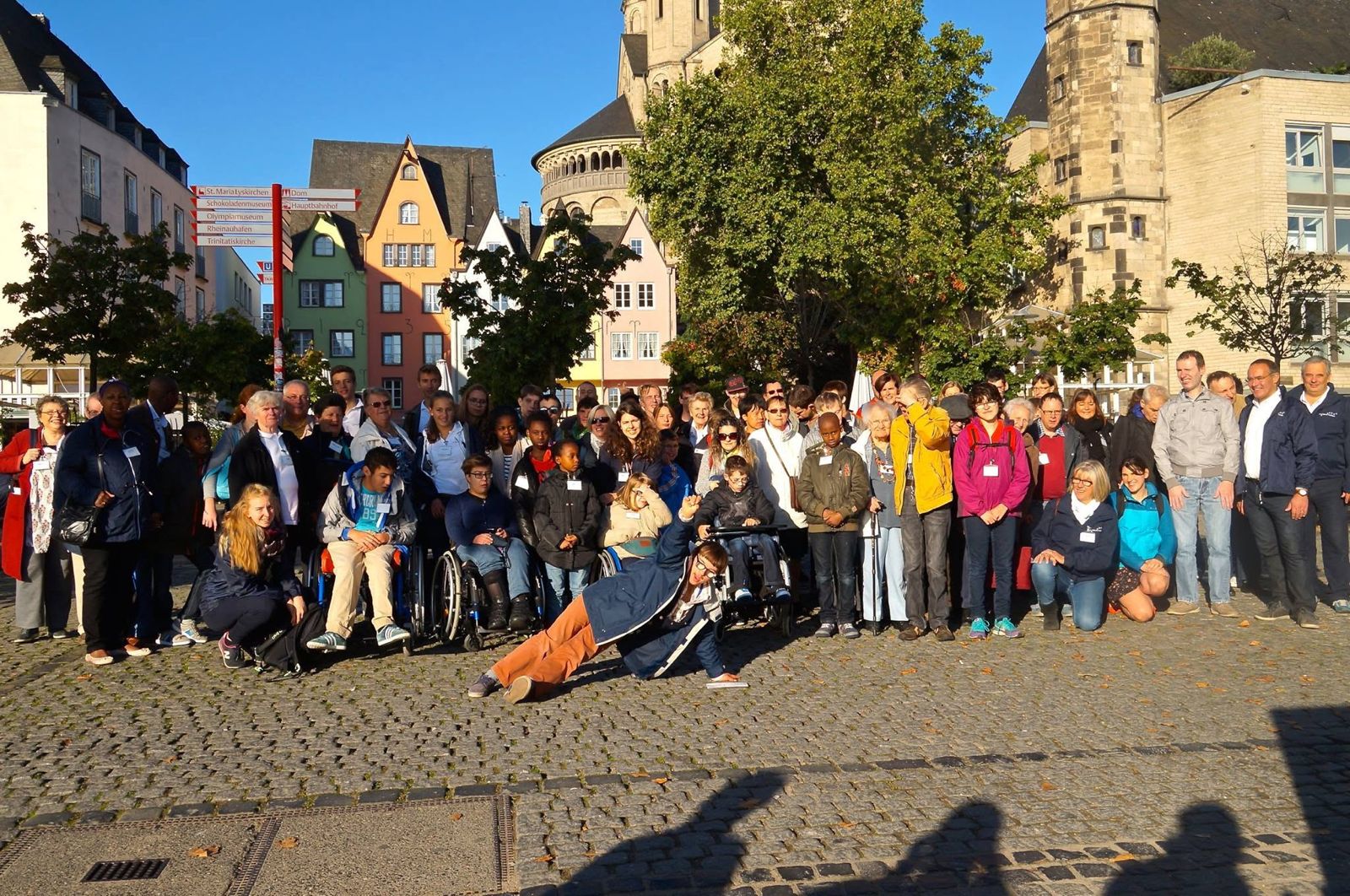 De groep poseert op een plein met oude gebouwen.