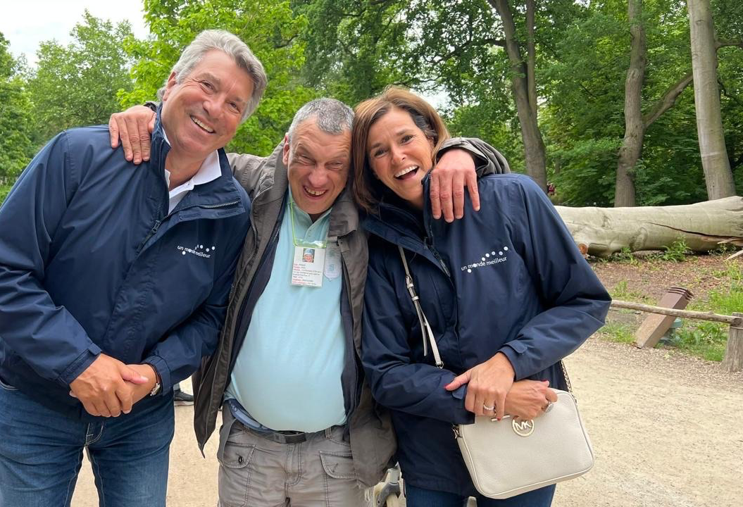 Patrick en Donatienne lachen arm in arm met een andere persoon tijdens een uitstap in een park