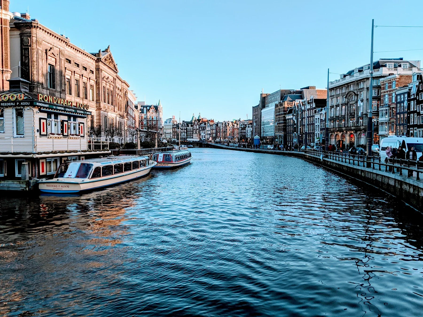 Gracht in Amsterdam met historische gebouwen en boten.